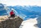 Happy people relax in cliff during trip Norway. Trolltunga hiking route