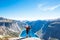 Happy people relax in cliff during trip Norway. Trolltunga hiking route