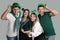 Happy people in St Patrick`s Day outfits on light grey background