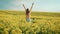 happy playful cheerful joyful woman jumps out of flowering field. Hands rased