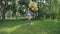 Happy, playful girl jumps with colourful balloons on the walk in sunny park