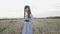 Happy, playful girl poses with hat in wheat field