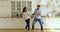 Happy playful millennial couple having fun together in kitchen.