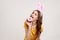 Happy playful teenager girl with brown hair in yellow casual T-shirt with pink bunny ears, biting tasty donut, easter symbol,