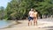 Happy and playful young interracial pregnant couple joyfully dancing at the beach.