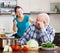 Happy playing mature couple cooking food