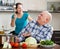 Happy playing mature couple in home kitchen