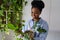 Happy pleased young African woman holding potted Philodendron plant enjoying home gardening