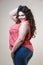 Happy plus size fashion model, fat woman on beige background