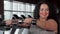 Happy plus size sportswoman lifting dumbbells at the gym