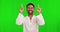 Happy, pointing and face of an Asian man on a green screen for presentation, advertising and promotion. Laughing