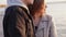 Happy portrait of couple in love stands in embraces at the evening lake