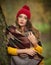Happy Portrait fashion of a beautiful young Caucasian woman with a red cap and scarf and yellow pullover in autumn park,red green
