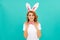 happy positive easter girl in bunny ears and bow tie on blue background