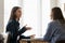 Happy positive millennial manager woman talking to female business partner