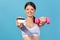 Happy positive woman athlete holding and showing credit card and dumbbell looking at camera with smiling, buying gym membership or