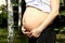 Happy pregnancy women walk in the garden near birches