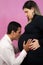 Happy pregnant Caucasian woman posing with her loving husband for a maternity shoot