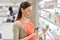 Happy pregnant woman choosing lotion at pharmacy