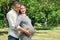 Happy pregnant woman, family couple in the park, green floral background. In anticipation of a miracle, a child. Family life,