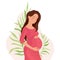 Happy pregnant woman holding her belly on a background with leaves, the birth of life. Pregnancy and motherhood. Happy pregnancy