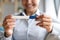 Happy pregnant woman holding pregnancy test in hands, closeup view