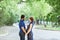 Happy pregnant woman with husband standing together in foliage.