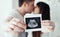 Happy pregnant woman and man with ultrasound picture of baby