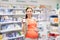 Happy pregnant woman with medication at pharmacy