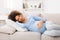 Happy pregnant woman napping on sofa, having sweet day dream