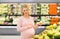 Happy pregnant woman with pear at grocery store