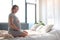 Happy pregnant woman sitting on bed with joy