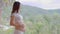 Happy Pregnant Woman standing in front of nature mountain view and stroking her big belly with love,Pregnancy of young woman enjoy