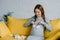 happy pregnant woman touching belly with newborn shoes