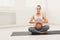 Happy pregnant woman training yoga in lotus pose