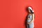 Happy pregnant woman wearing Santa hat for Christmas party on red background. Expecting baby