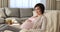 Happy pregnant young woman resting on comfy armchair at home