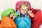 Happy preschooler girl choosing her school bag from a colorful s