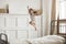 Happy preschooler girl jump high relaxing in bedroom