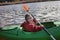 Happy preteen girl kayaking on river, paddle in the hand, summer camp activity, extreme sport