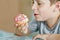 Happy preteen school boy eating sweet donut indoor. Blond child in domestic kitchen or in school canteen Cute kid and