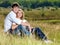 Happy pretty couple sitting in meadow