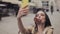 Happy Pretty Girl Making Selfie or a Video Call Holding her Smartphone Vertical Smiling and Blowing a Kiss into Camera.