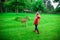 Happy pretty little girl in rubber boots feeds deers in the nature park at autumn