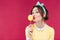 Happy pretty pinup girl eating and kissing yellow lollipop