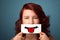 Happy pretty woman holding card with funny smiley