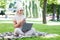 Happy pretty young islamic female in hijab with laptop chatting on phone, working in park