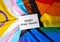 HAPPY PRIDE MONTH inscription positive quote phrase Greeting card on Rainbow LGBTQIA flag made from silk material