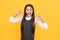 Happy primary school girl child smile pointing thumbs fingers yellow background, education