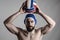 Happy professional water polo player holding ball over his head looking at camera